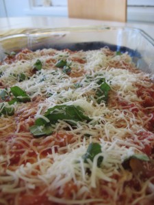 Layers of sauce, cheese, and basil in homemade lasagna